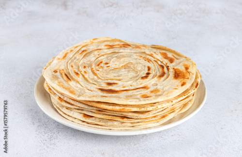 Stack of traditional Indian paratha flatbreads on white background. Indian food.