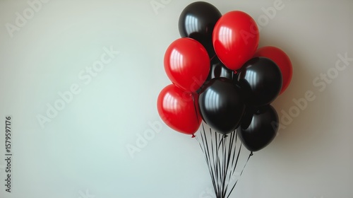 Colorful Black and Red Balloons Arranged Against a Light Background for Celeb...