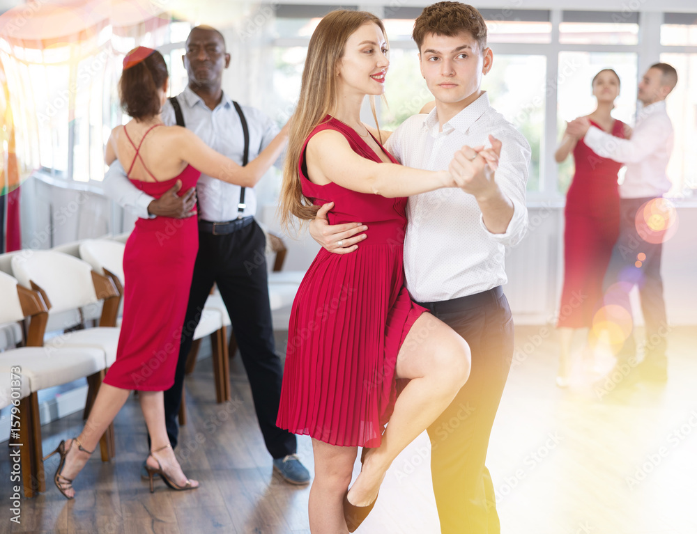 Naklejka premium Young man and young woman dance couple tango dance in studio