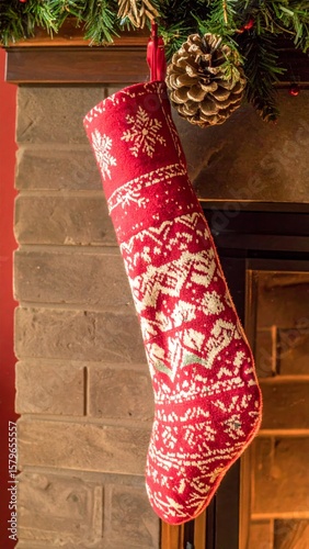 Red Christmas Stocking with White Snowflakes Hanging on a Brick Fireplace Mantel