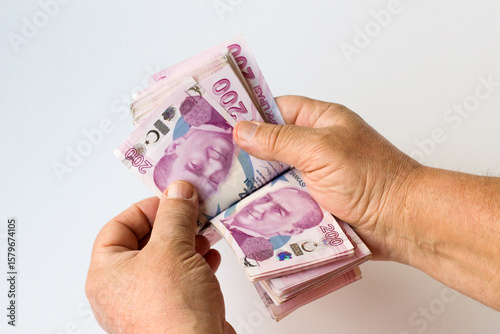 Unknown male hands counting Turkish Money Banknotes on white surface,close up