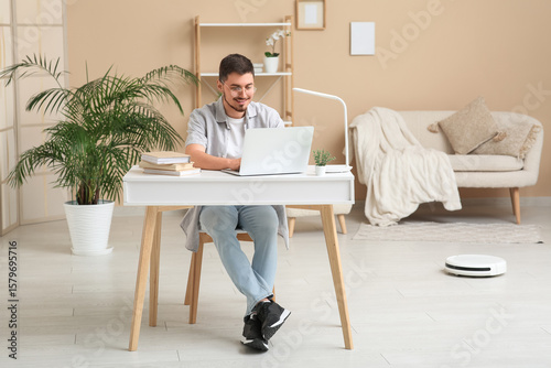 Young man using laptop at t...