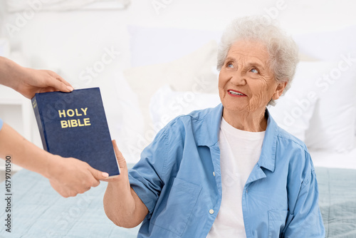 Caregiver giving Bible to s...