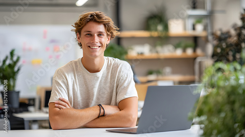 A young entrepreneur working in a startup office.	A young, energetic entrepreneur works on a laptop at a creative, open-plan startup office, looking confident and determined.
