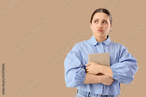 Thoughtful woman with book ...
