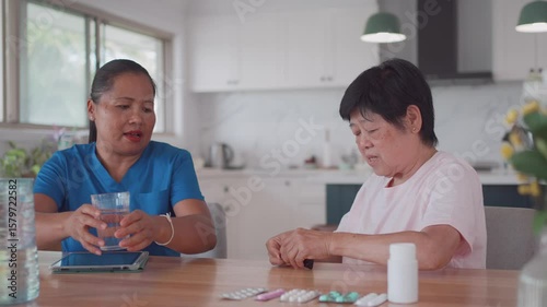 Asian health care worker visiting elderly woman at home, home nurse, home care service concept
