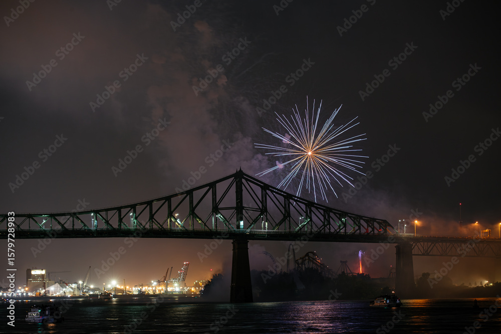 Fototapeta premium Drone flight through holiday fireworks above water with reflection on the black sky background