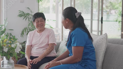 Asian health care worker visiting elderly woman at home, home nurse, home care service concept
