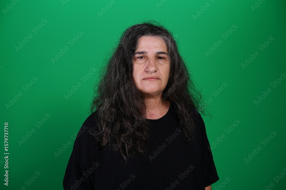 Fototapeta premium Unedited Portrait of Woman’s Face Expressing Various Emotions – Green Studio Background