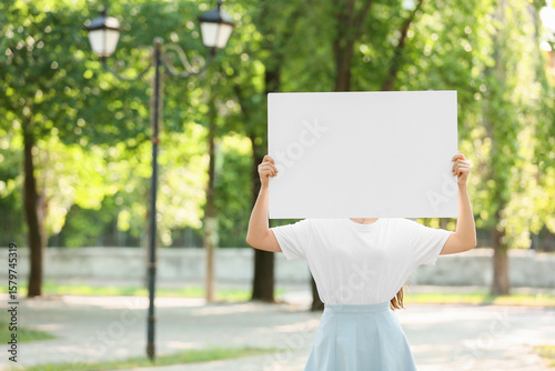 Young woman holding blank p...