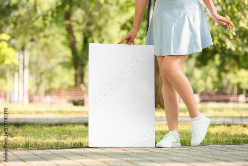 Young woman holding blank p...