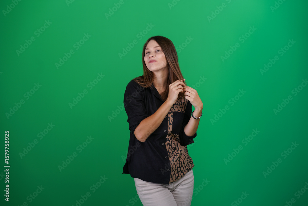 A young woman poses in a studio with a green background, showing natural emotions, full of expressions and dynamic movements. Unedited image A young woman poses in a studio with a green background, showing natural emotions, full of expressions and dynamic movements. Unedited image