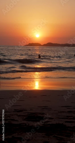 Couple far away in the beach at sunset