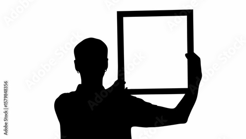 Silhouette of a person holding a rectangular frame with both hands against a white background image view
