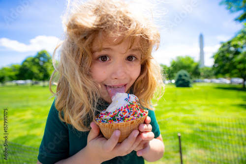 Summer kids face. Child eating ice cream. Summer sweets. Kid licking ice cream cone in summer park. Little funny boy face with ice-cream close-up. Summer child funny portrait. Kids fun face.