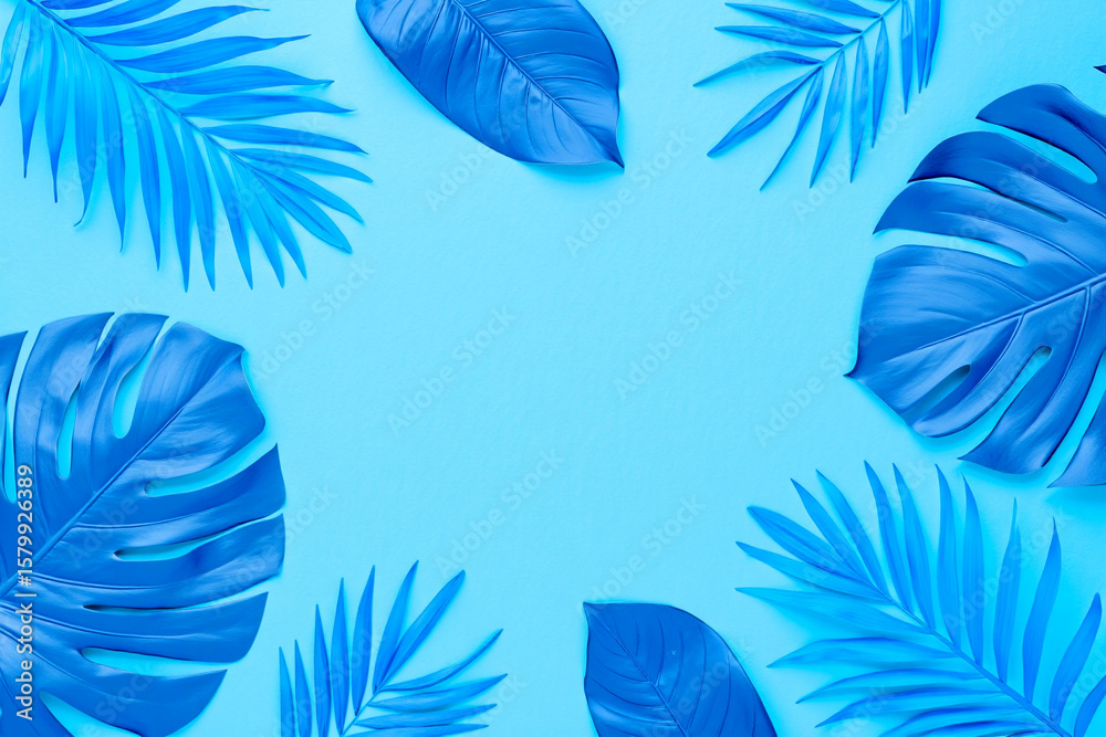 Naklejka premium Tropical blue leaves are arranged on a light blue background