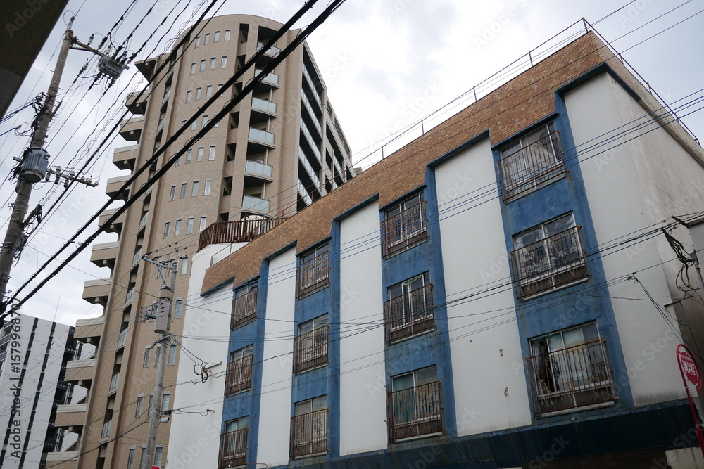 Fototapeta premium 電線と建物の織りなす街の風景