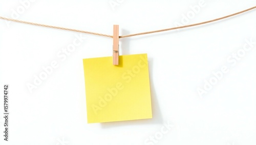 A single yellow note card held by a wooden clothespin on a string