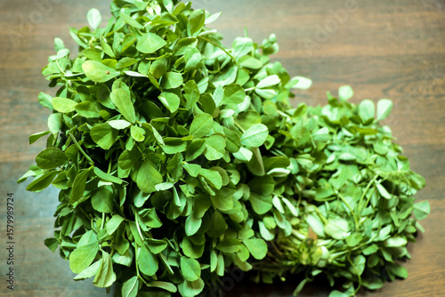 Fresh Fenugreek Leaves (Methi) on Wooden Surface
