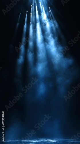 Descending beams of soft blue light move through a dark setting, resembling a theatrical spotlight loop with a cinematic feel.