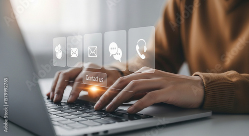 Person using a laptop with contact us icons for communication and support