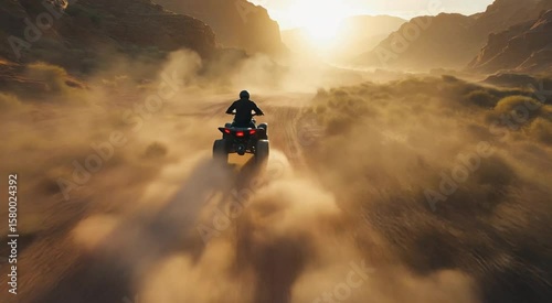 Atv rider exploring the arid desert landscape at golden hour dust trail