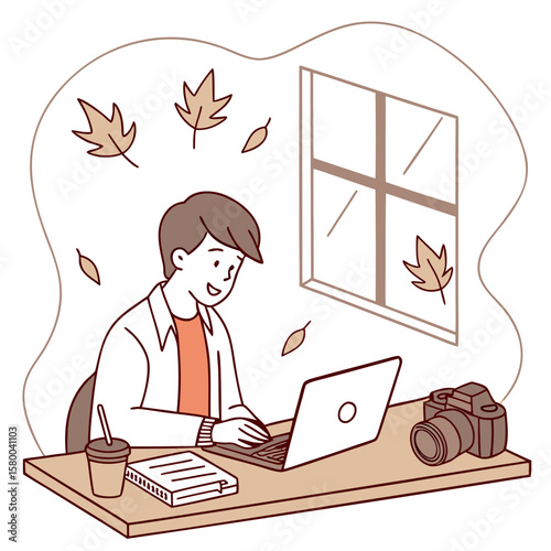 A young man working on a laptop at a desk with a camera, notebook, and coffee, with autumn leaves falling outside the window