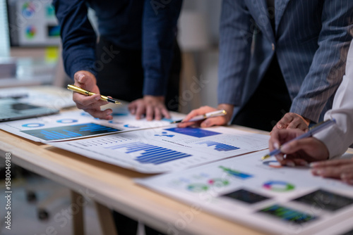 Wallpaper Mural A group of people are looking at a table with graphs and charts Torontodigital.ca