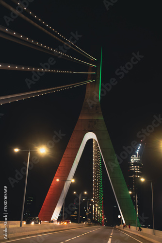 Central perspective of the Alassane Ouattara Bridge illuminated at night in Abidjan