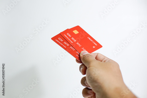 Close up of hand with red credit card isolated on white background. Shopping, finance and people concept
