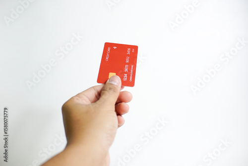 Close up of hand with red credit card isolated on white background. Shopping, finance and people concept