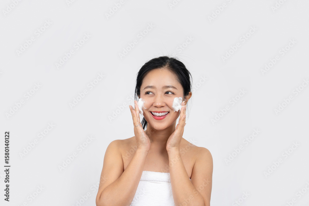 Smiling woman washing face with facial foam Smiling woman washing face with facial foam