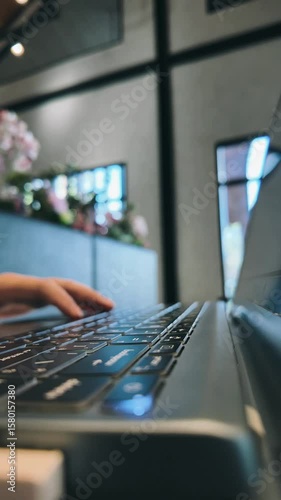 Time lapse of side view close-up  man's hands typing on keyboard on laptop at table in cafe on holiday. Concept of working outdoors, comfortable workspace or freelance career, footage vertical