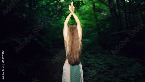 Woman in the forest. View from the back. Enjoying nature.