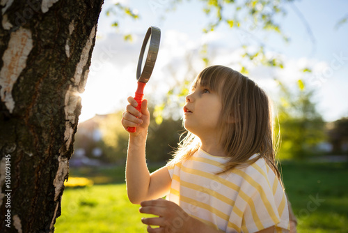 Girl exploring nature with a magnifying glass in Warsaw, Poland