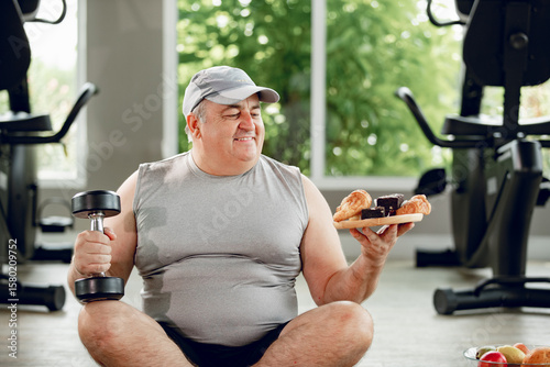 Foto Man with dumbbell and Donut looking at camera
