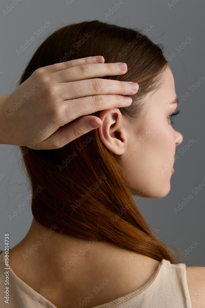 Naklejka premium beauty woman with red hair gently touching head, natural skin, side profile, soft lighting, minimalistic background, calm and serene mood
