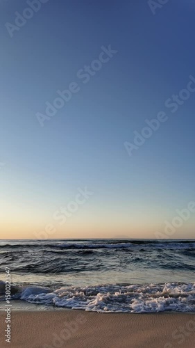 Sunrise on the coast with calm, rolling waves