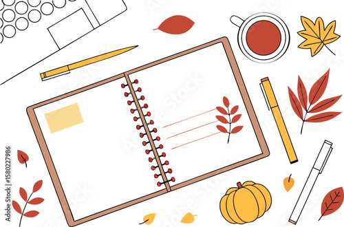 Autumnal stationery arrangement featuring a notebook, pens, leaves, a pumpkin, and a cup of tea on desk