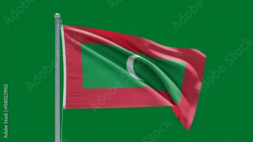 Maldives Flag in the Wind: The vibrant national flag of the Maldives, with its striking red, green, and crescent moon design, waves proudly in the wind, against a verdant backdrop.