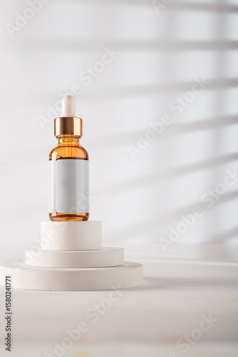 Dropper bottle with blank label, no brand template. Cosmetics mockup jar on concrete decorative stand, white backdrop. Copy space. Beauty product advertising banner