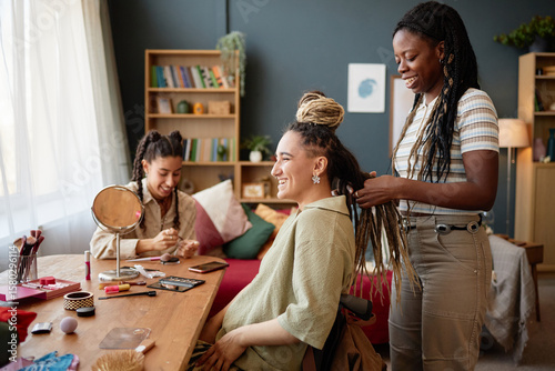 Bilde på lerret Young adult Caucasian woman sitting in wheelchair smiling while Black girlfriend