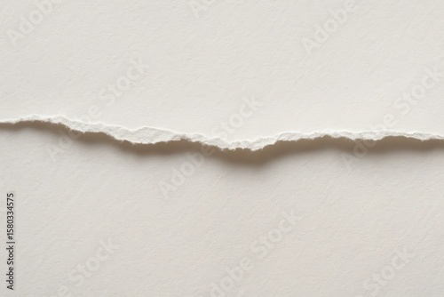 A solitary tear in white paper, symbolizing a moment of disruption or change