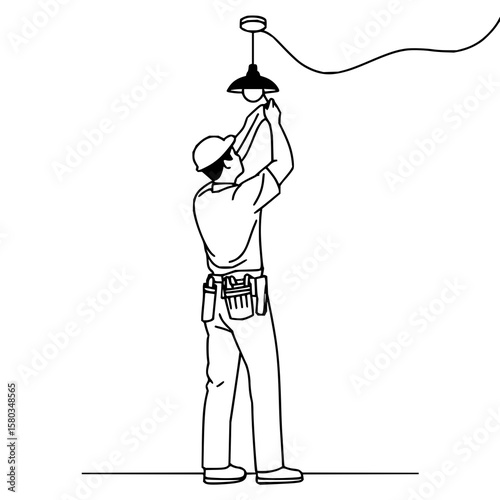 Electrician wearing a hard hat installing a light bulb in a hanging lamp with a tool belt on his waist