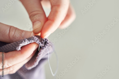 Foto Close-up of adult hands sewing fabric with needle and thread for handcrafted clothing