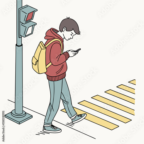 A young man with a backpack crossing a crosswalk while looking at his phone near a traffic light pole
