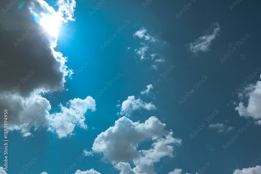 Fototapeta premium Clear blue sky background with clouds and bright sun. Blue sky and white clouds background. Sunny day
