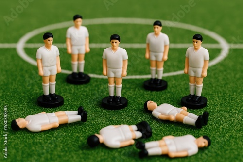 Miniature football figures positioned on the field with some fallen and lying down, illustrating excess and unnecessary players