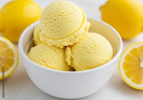 Close-up of a white bowl filled with three scoops of lemon ice cream, garnished with a mango slices