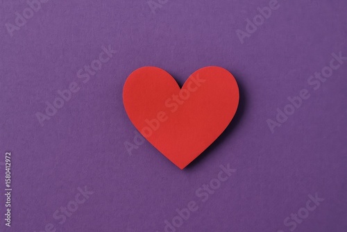 Overhead shot of a paper heart on a purple background for Valentine's Day
